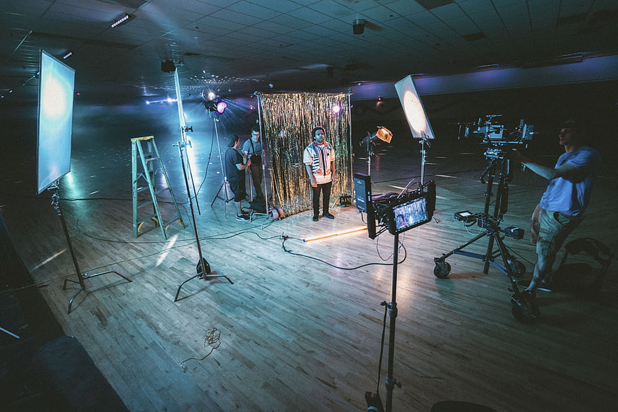 Film crew shooting video in studio with lights and camera