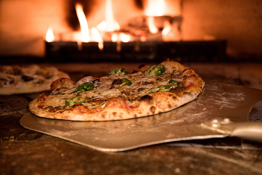 Freshly Baked Pizza on Metal Peel in Wood-Fired Oven