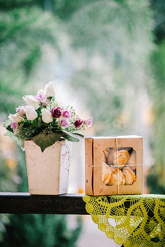 Rustic gift box with cookies and flowers on wooden railing