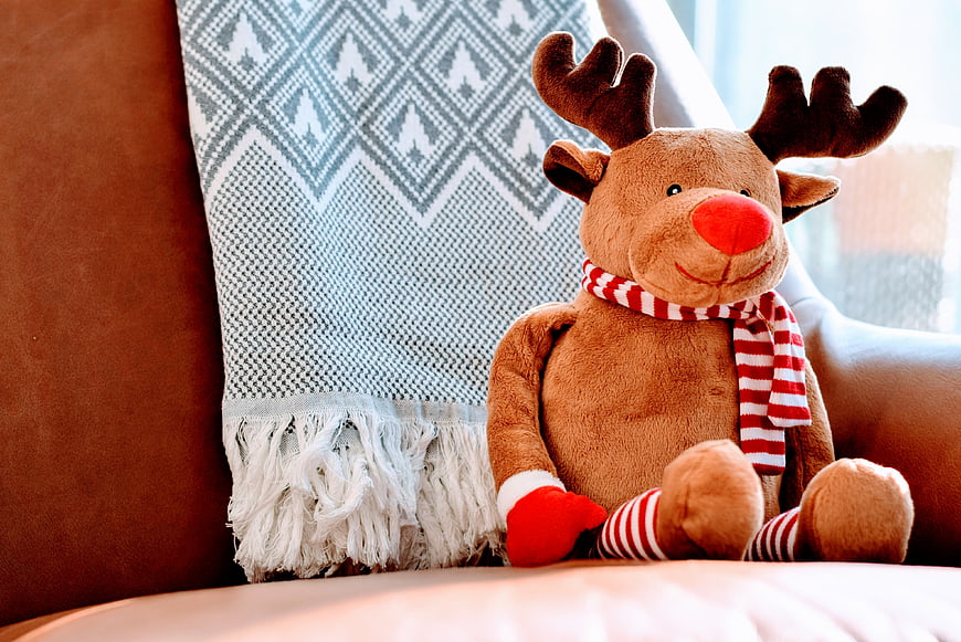 Cute Plush Reindeer Toy on Sofa with Christmas Scarf