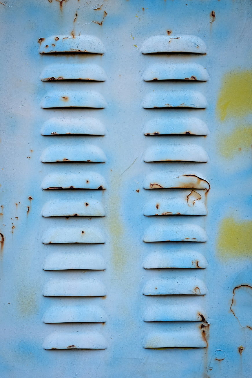 Rusty blue metal vent texture with weathered paint