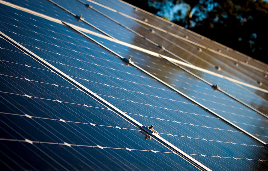 Close-up of blue solar panels with sunlight reflection