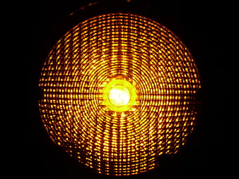 Close-up of glowing amber warning light with grid pattern
