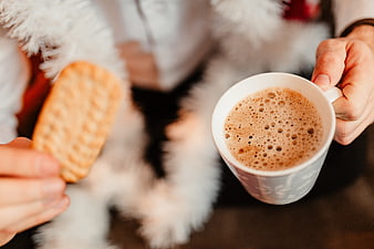 Cozy hands holding hot chocolate and biscuit