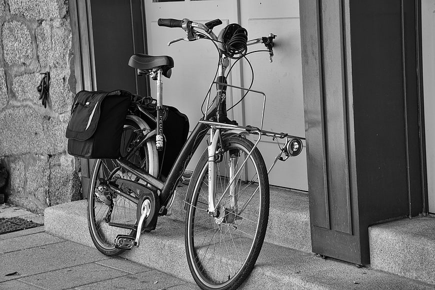 Black and white commuter bicycle with panniers on stone steps
