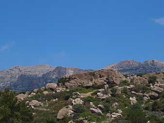 Rugged mountain landscape with rocky terrain and blue sky