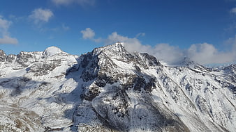 Snow-Covered Mountain Peaks Under Blue Sky