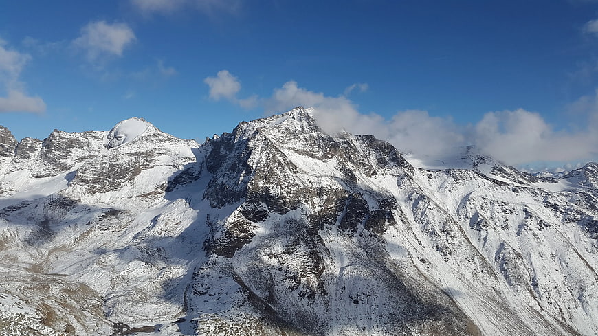 Snow-Covered Mountain Peaks Under Blue Sky