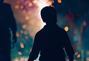 Silhouette of Boy Watching Fireworks at Night