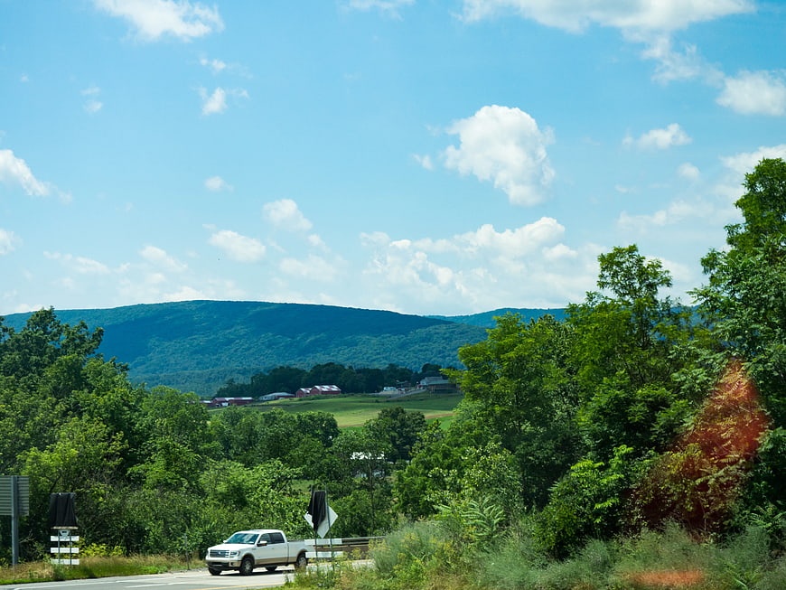White Pickup Truck Driving on Rural Road with Mountain View