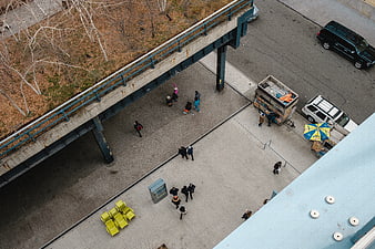 High angle view of urban plaza with pedestrians and food cart