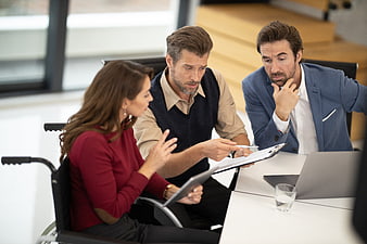 Diverse business team meeting with woman in wheelchair