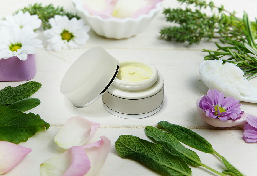 Natural Herbal Skincare Cream Jar With Fresh Flowers And Green Leaves