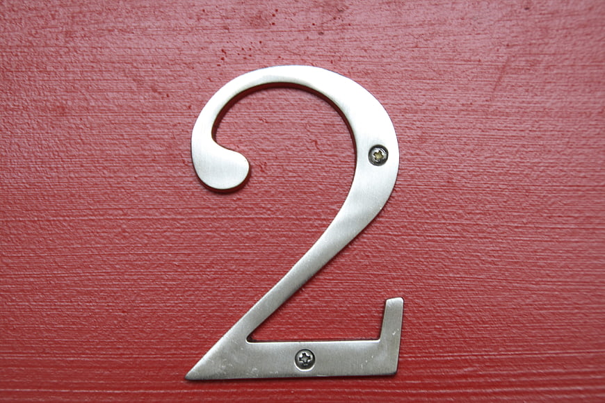 Silver metal number 2 on red textured door