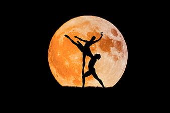 Silhouette of Acrobatic Dancers Against Giant Super Moon