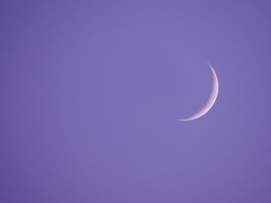 Crescent moon in purple twilight sky