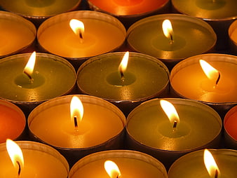 Close-up of burning tea light candles in a grid pattern