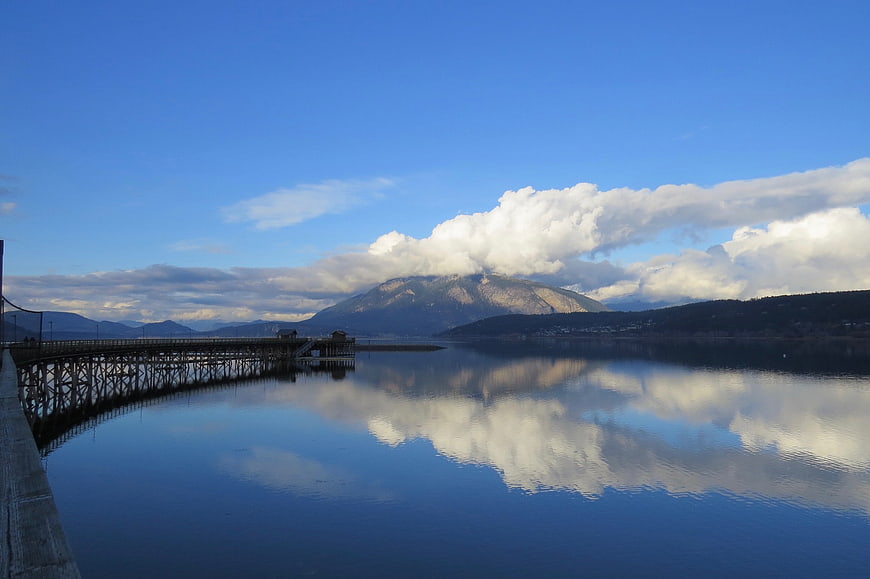 Serene Lake Reflection with Mountain and Wooden Pier