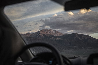 Mountain landscape view from car windshield with dramatic clouds