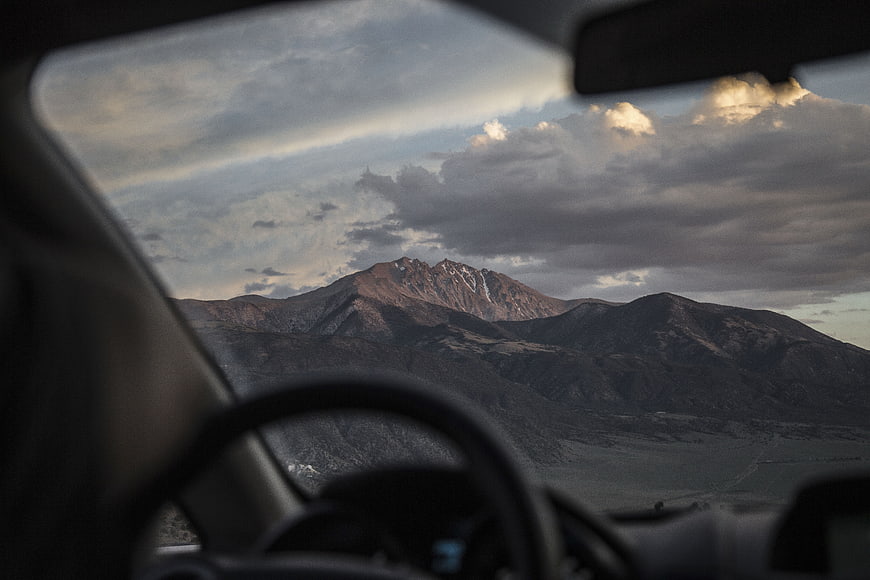 Mountain landscape view from car windshield with dramatic clouds