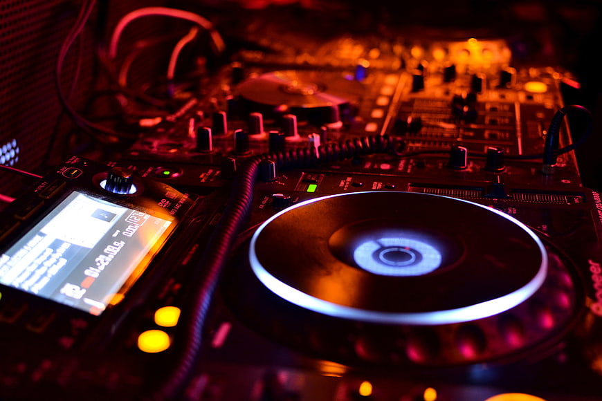 Close-up of DJ turntable and mixer in club lighting