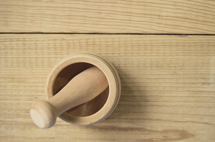Wooden mortar and pestle on rustic table background