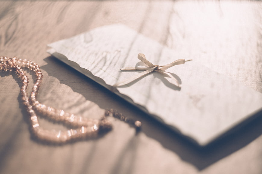 Vintage Wedding Invitation with Ribbon and Necklace on Wood