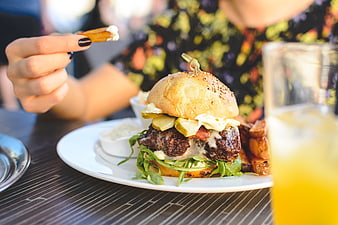 Juicy Gourmet Burger with Fries and Drink on Outdoor Table