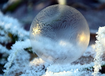 Frozen Soap Bubble with Intricate Frost Patterns on Snow