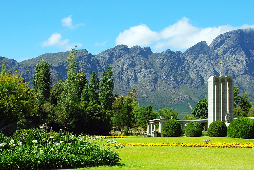 Landscape of manicured gardens with mountains and monument