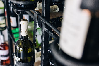Close-up of wine bottles on a rustic metal rack