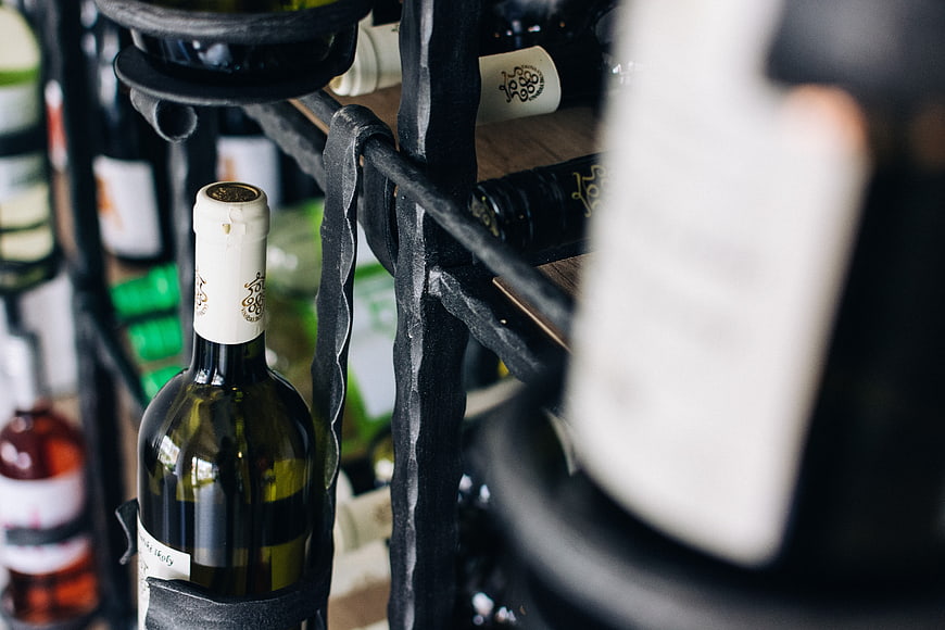 Close-up of wine bottles on a rustic metal rack