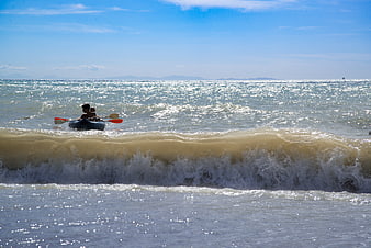 Kayaking in Ocean Waves on a Sunny Day