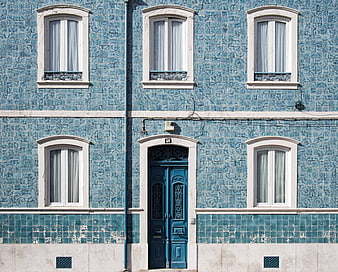 Blue Tiled Building Facade With White Windows And Ornate Door