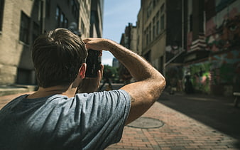 Man Taking Photo with Camera on Urban Street