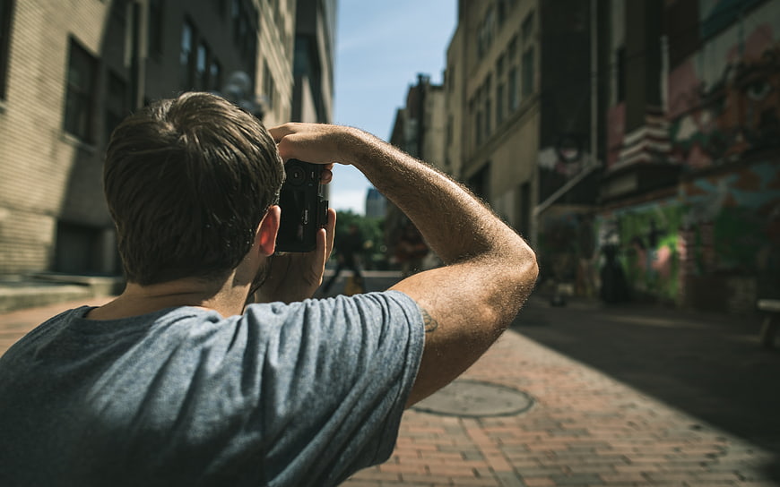 Man Taking Photo with Camera on Urban Street