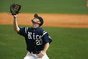 Baseball Player in Blue Rice Jersey Catching Ball