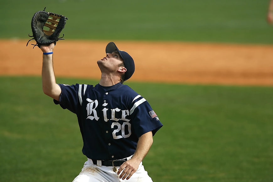 Baseball Player in Blue Rice Jersey Catching Ball