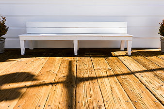 White Wooden Bench on Sunlit Deck with Shadows