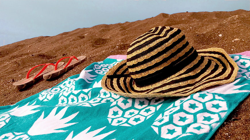 Straw Beach Hat and Flip Flops on Turquoise Towel
