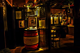Dimly lit Irish pub interior with whiskey barrel and vintage decor