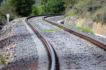 Curved railway tracks winding through green forest landscape