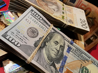 Stacks of US 100 Dollar Bills and Euro Banknotes
