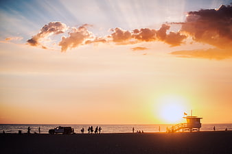 Silhouetted Beach Sunset with Lifeguard Tower and People