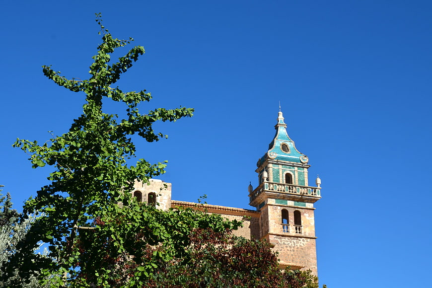 Historic church tower with green tiles against blue sky