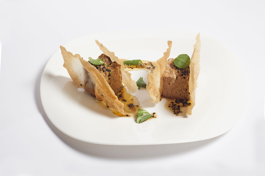 Gourmet plated appetizer with crispy garnish on white plate