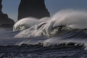 Powerful Ocean Waves Crashing Against Dark Sea Stacks