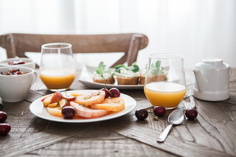 Healthy breakfast with fruit slices, juice, and toast on rustic table