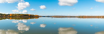 Panoramic autumn lake landscape with perfect cloud reflections