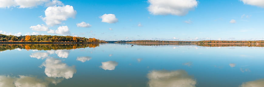 Panoramic autumn lake landscape with perfect cloud reflections